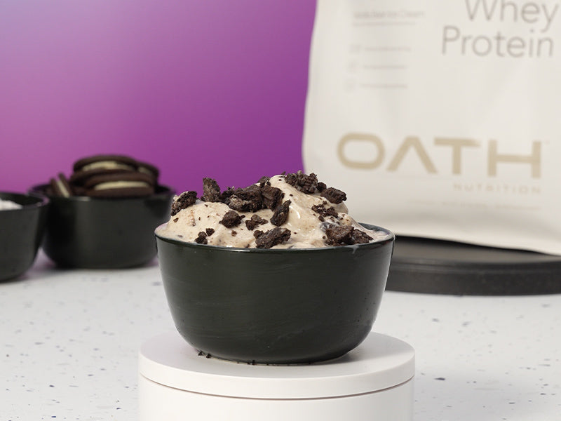 Oath Cookies and Cream Whey Protein Ice Cream on a podium with Oath Vanilla Bean Whey Protein in the background