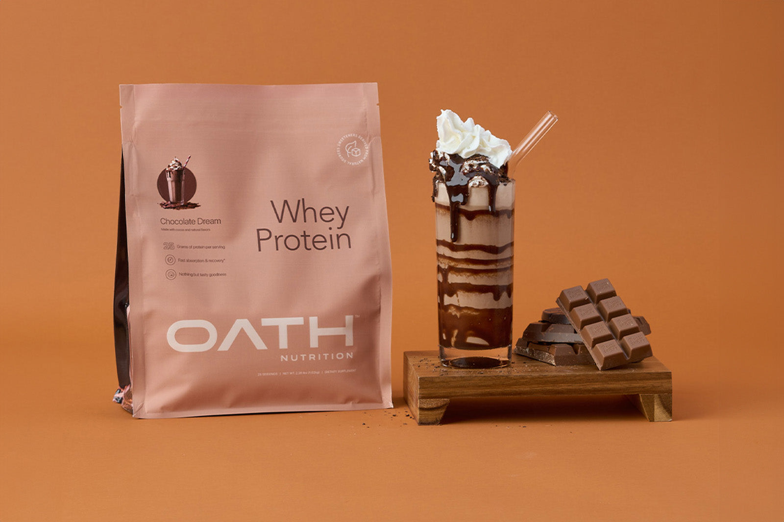 Oath Chocolate Dream Naturally Sweetened whey protein next to a delicious chocolate protein milkshake and chocolate.