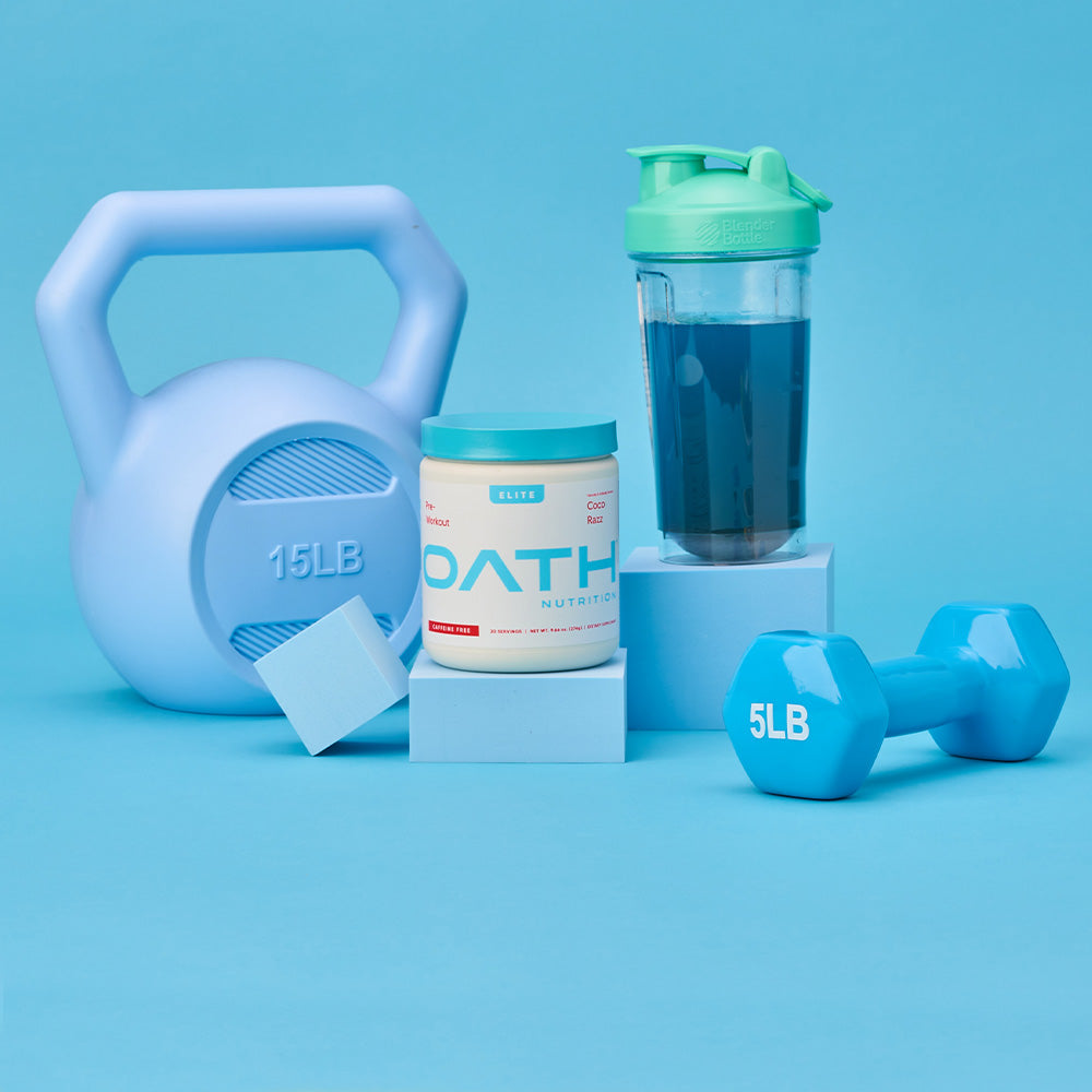 Oath Caffeine-Free Pre-Workout with weights and a BlenderBottle brand shaker bottle next to it
